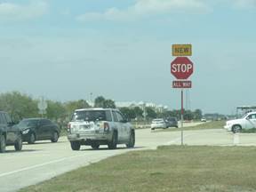 Photo of a NEW placard placed above a STOP sign to alert motorists to a change in the intersections traffic control.